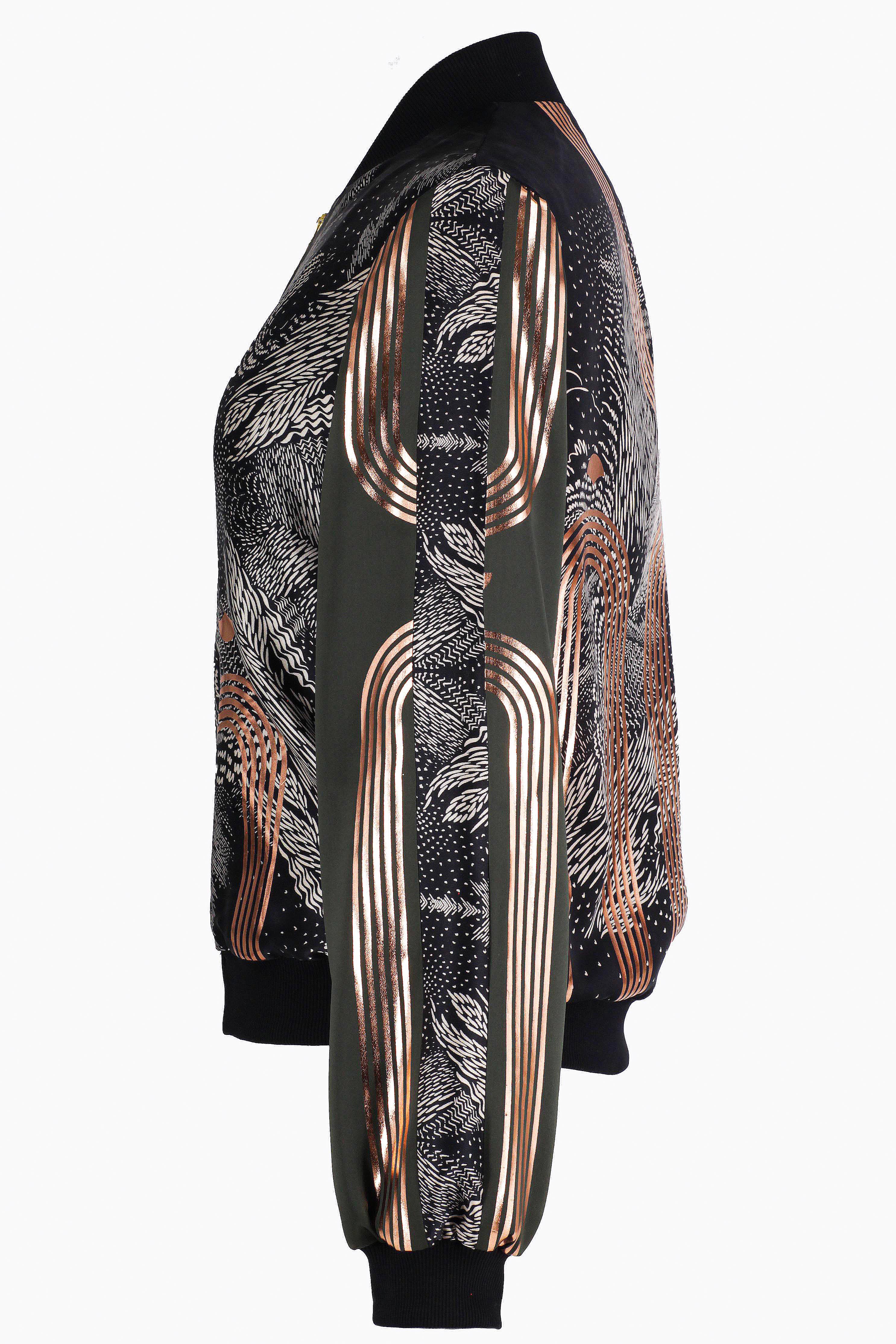 The side of a hand printed silk bomber bomber jacket with hand printed designs in black, olive green and rose gold