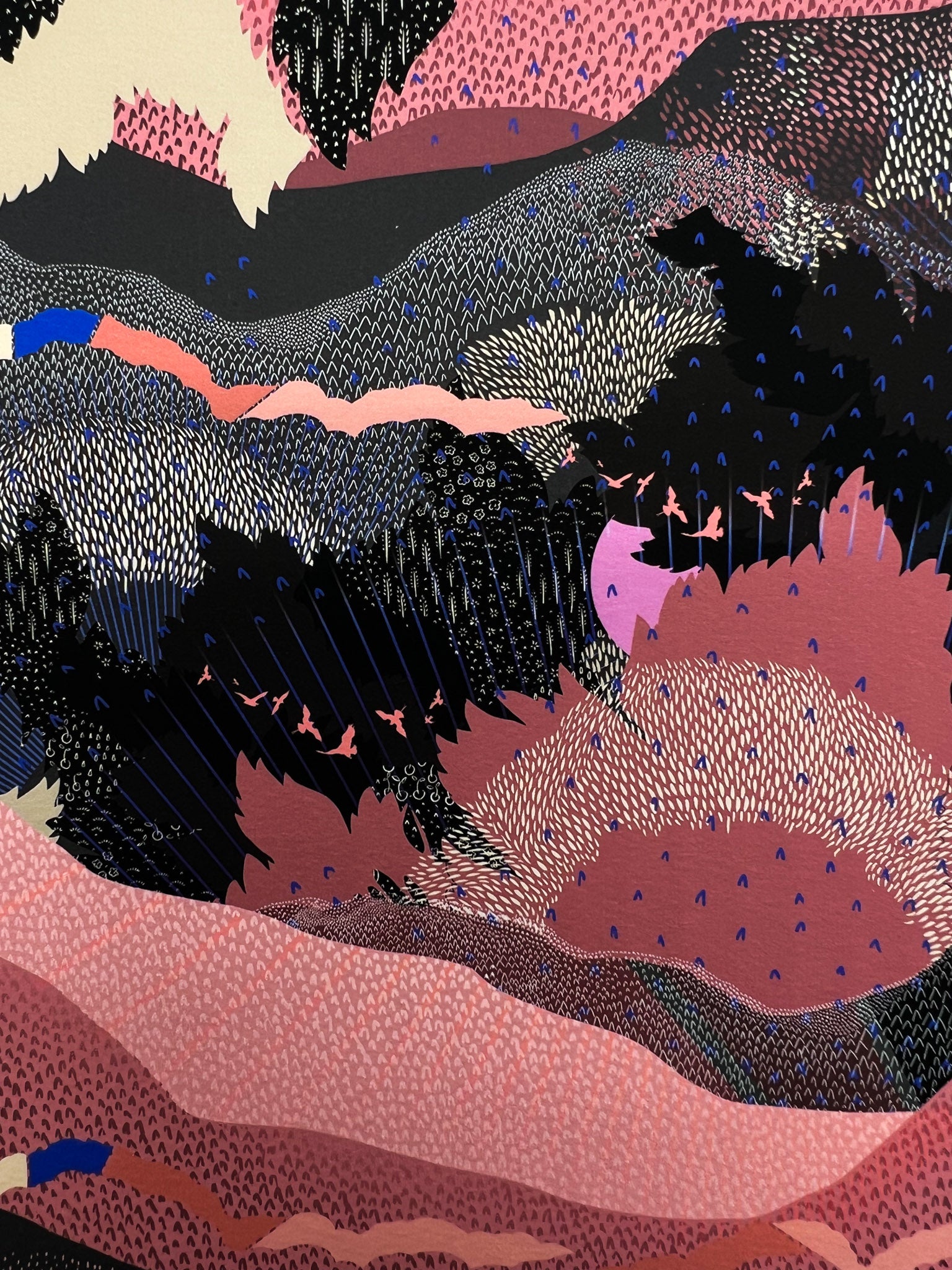 A close up of a giclee print in black and pink with a landscape design and bright pink suns