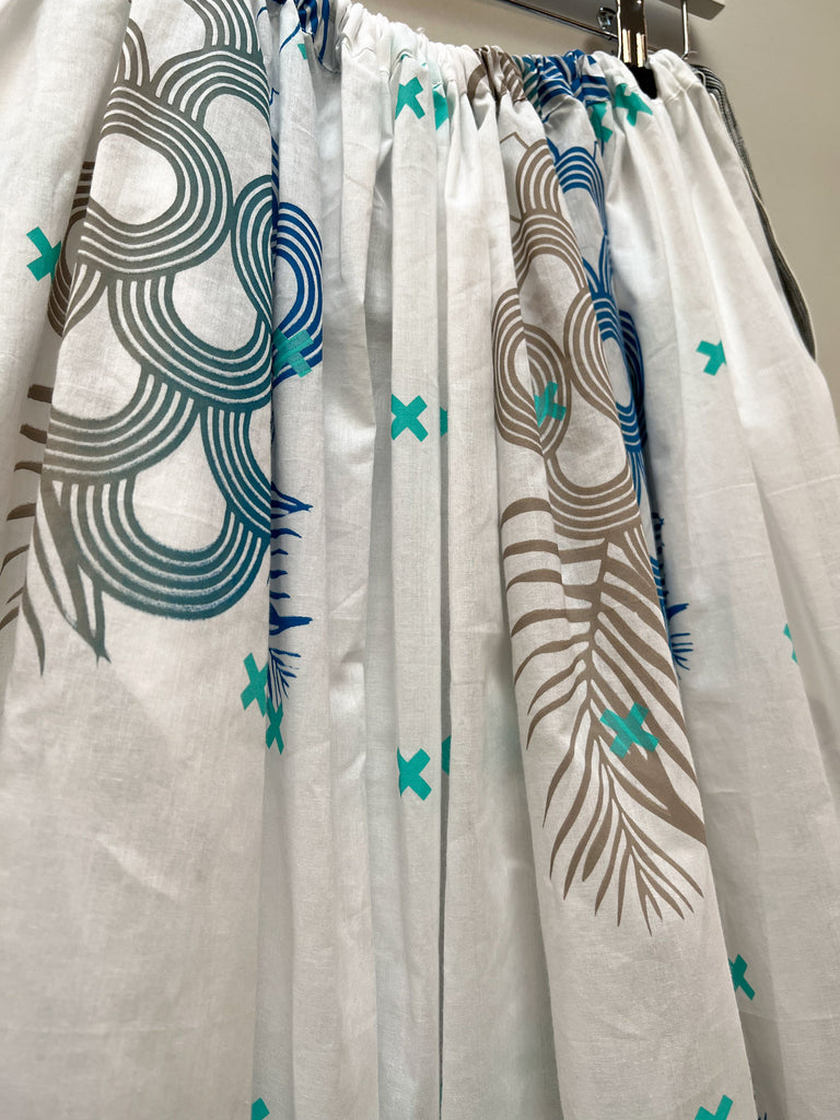 A close up of an organic cotton hand printed midi skirt in white, blue and grey