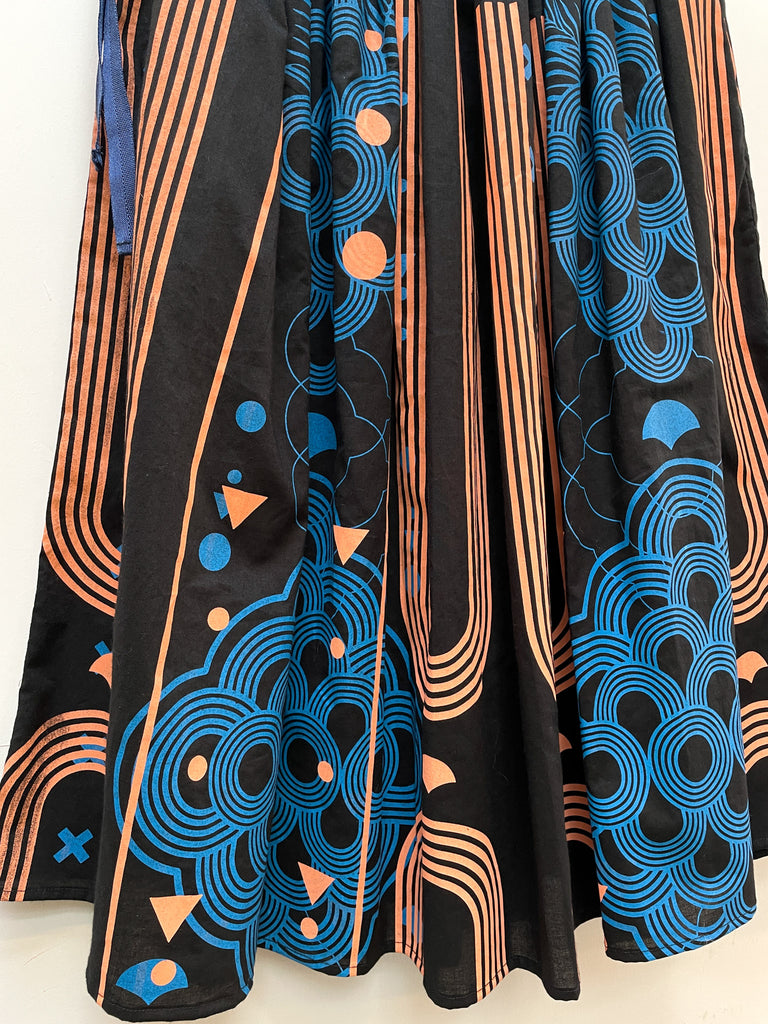 A close up of an organic cotton hand printed midi skirt in black, blue and coral 