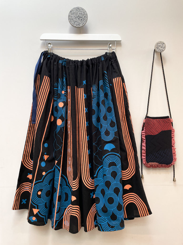 An organic cotton hand printed midi skirt in black, blue and coral 