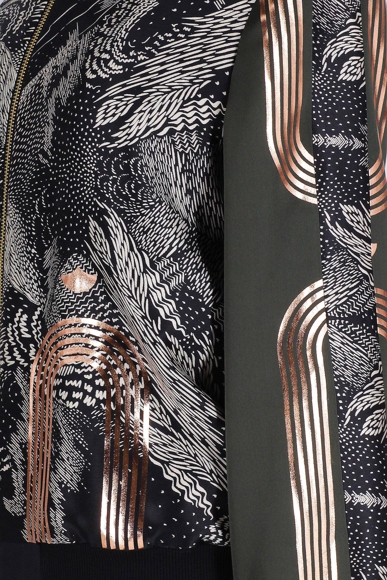 A close up of hand printed silk bomber bomber jacket with hand printed designs in black, olive green and rose gold