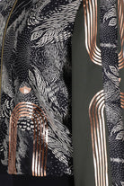 A close up of hand printed silk bomber bomber jacket with hand printed designs in black, olive green and rose gold