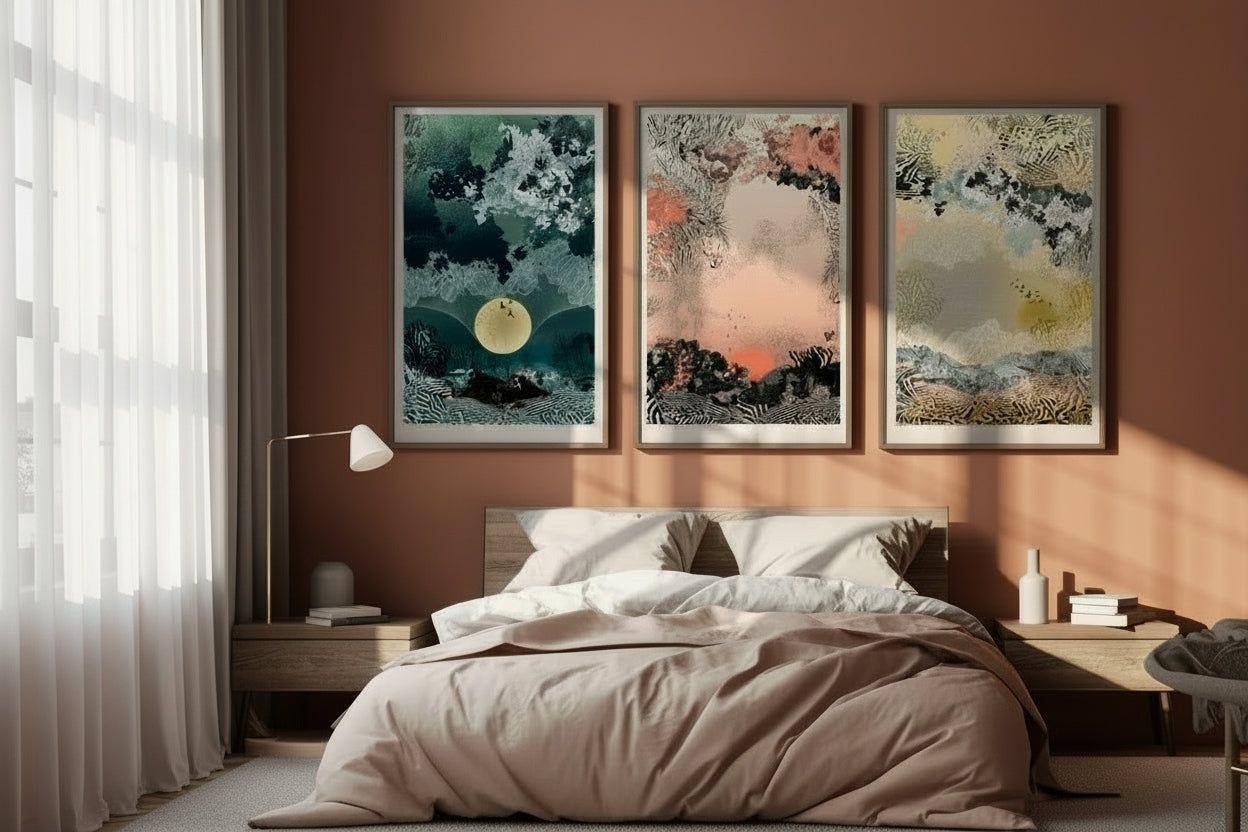 A mock up of a giclee print with Sunrise design in oranges and blacks in a wood frame, above a bed