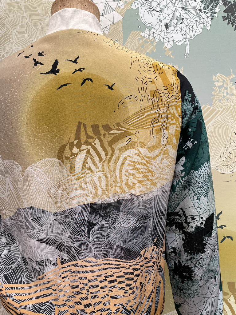 An up close back of a silk printed bomber jacket in both dark and light prints 