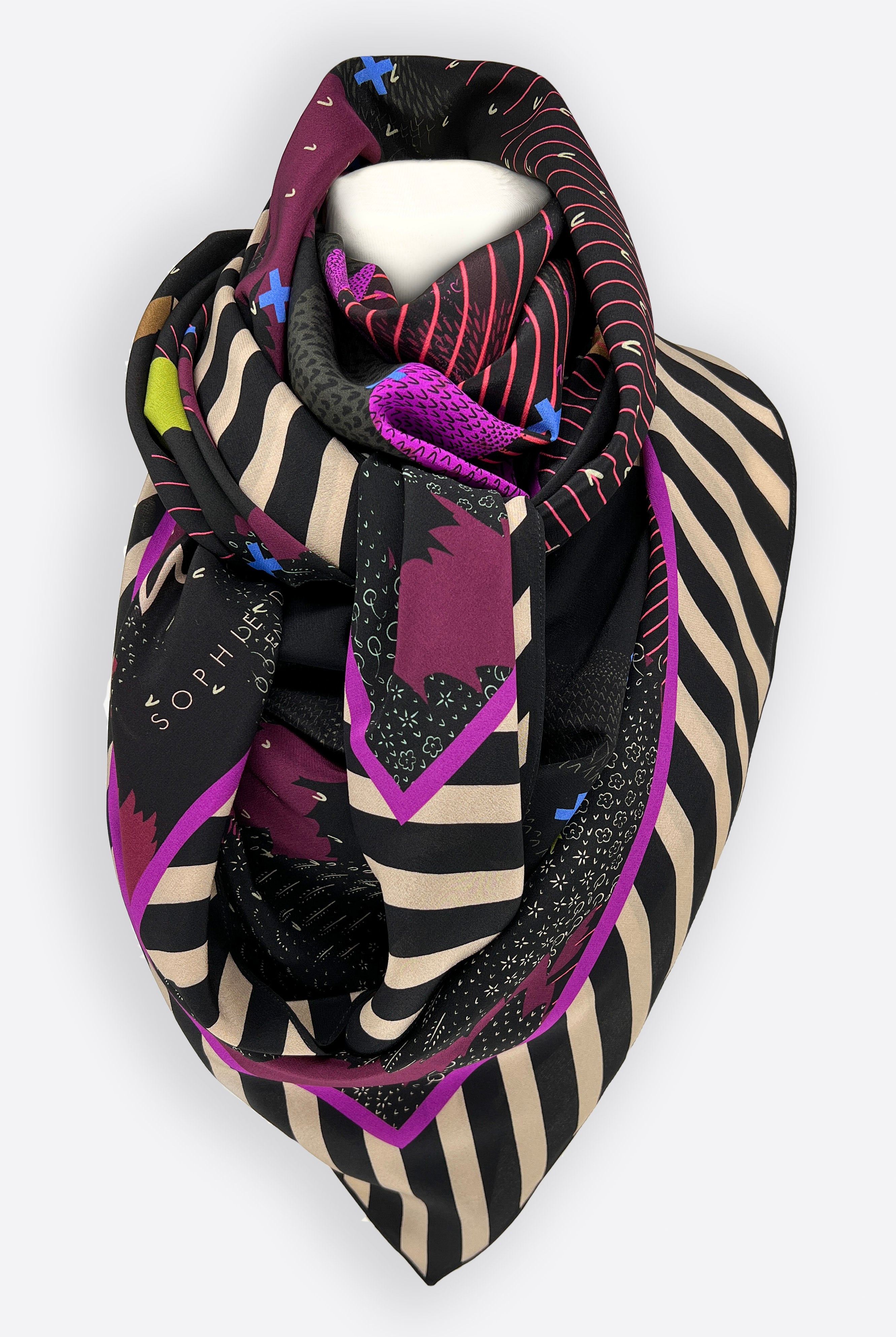 A large silk scarf tied around the neck of a mannequin in purple, black and beige.
