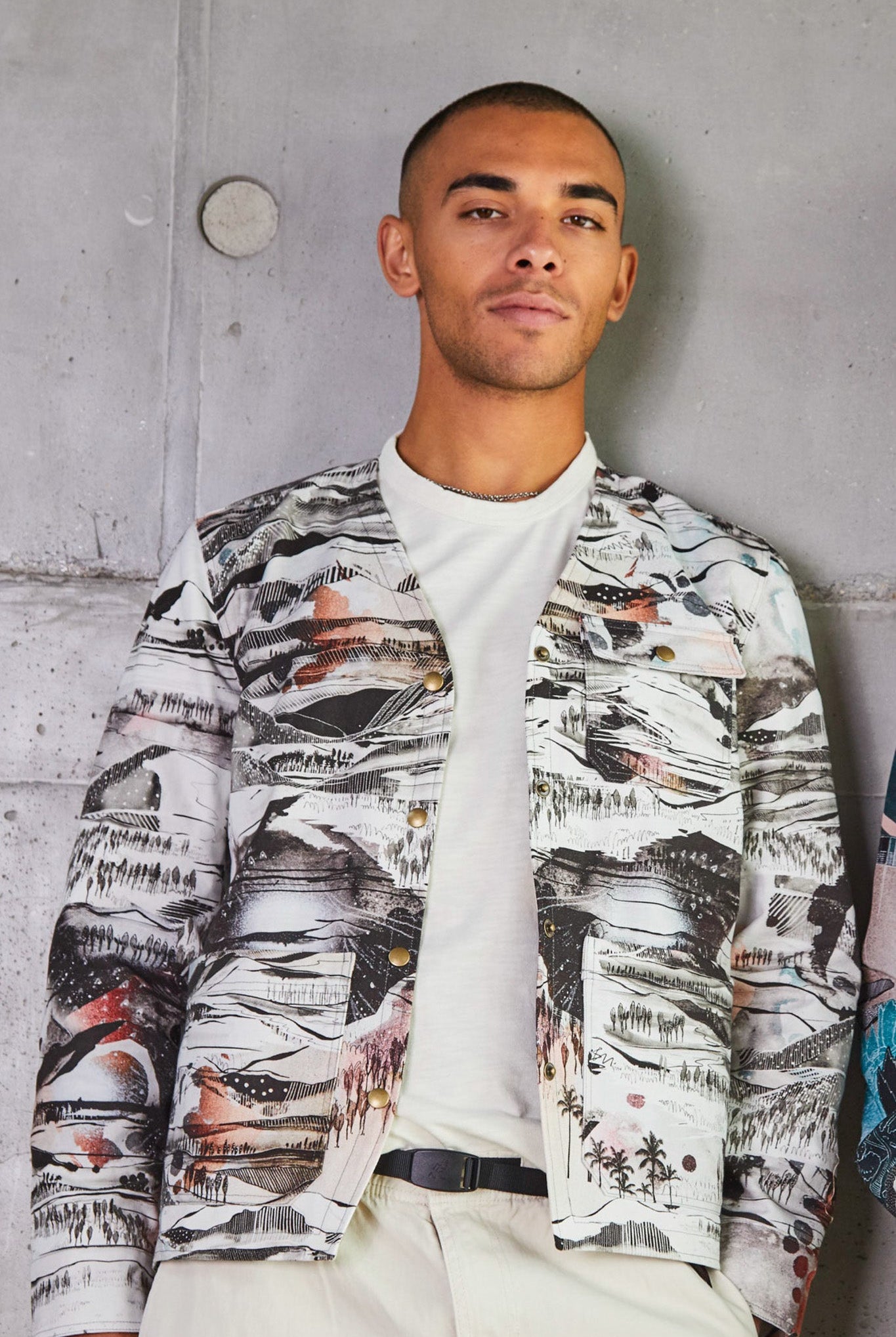 A male wearing a mens utility jacket with Japanese-inspired landscapes print in white, black and red