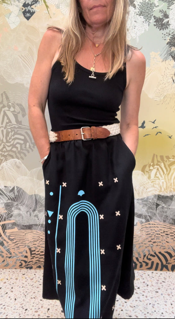 A woman wearing a tencel twill printed midi skirt in black and blue