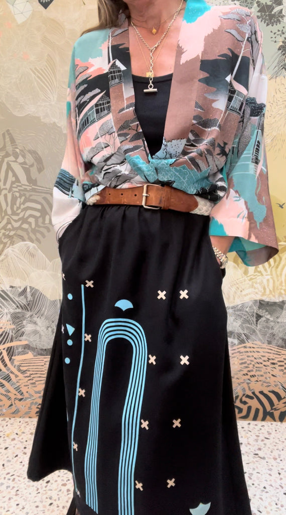 A woman wearing a tencel twill printed midi skirt in black and blue