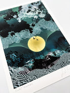 A giclee print of a large yellow moon, birds and a blue landscapes design