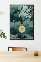 Framed canvas print on a wall above a wooden table with a glass and chair.