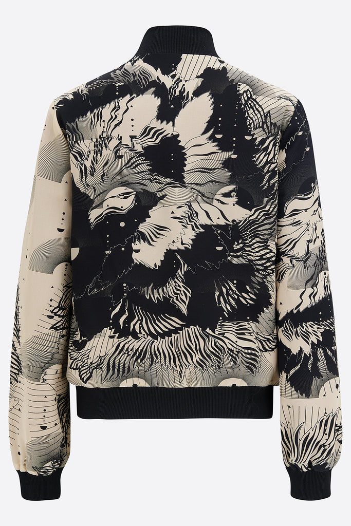 The back of a printed silk bomber jacket in a navy and cream abstract floral and geometric print