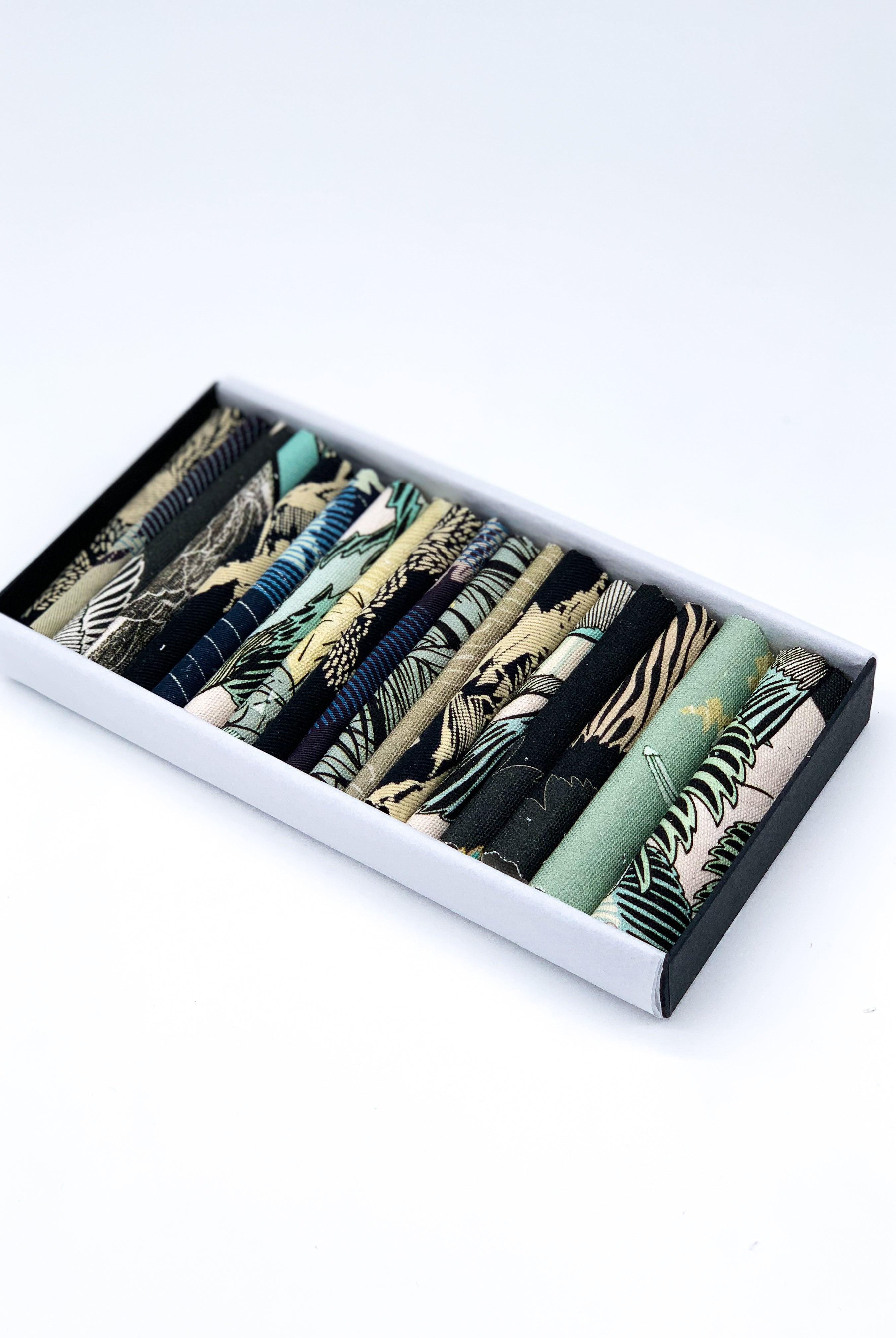 An off- cut fabric box containing dark tone pieces 