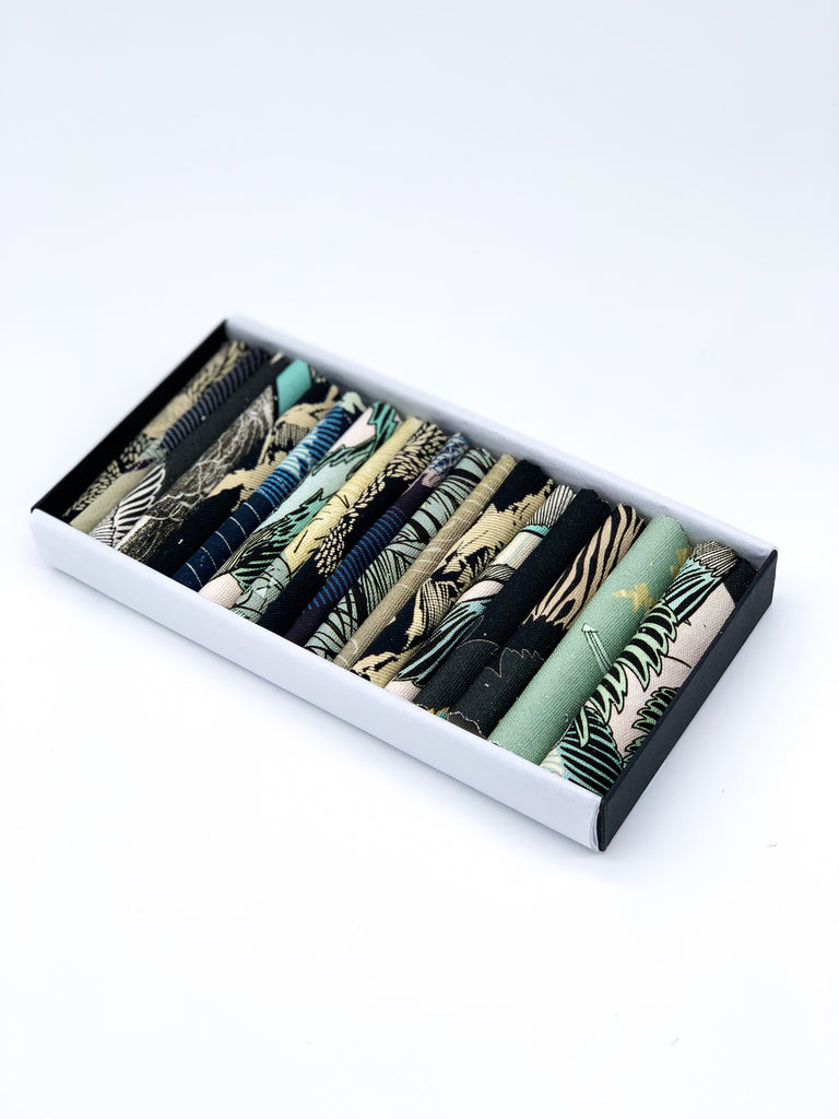 An off- cut fabric box containing dark tone pieces 