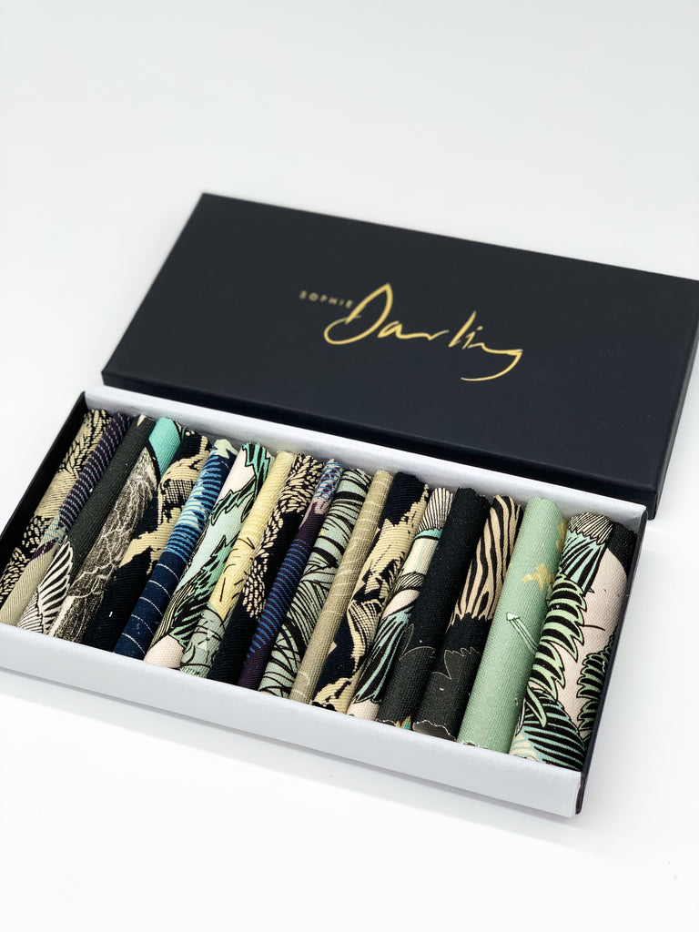 An off- cut fabric box containing dark tone pieces 