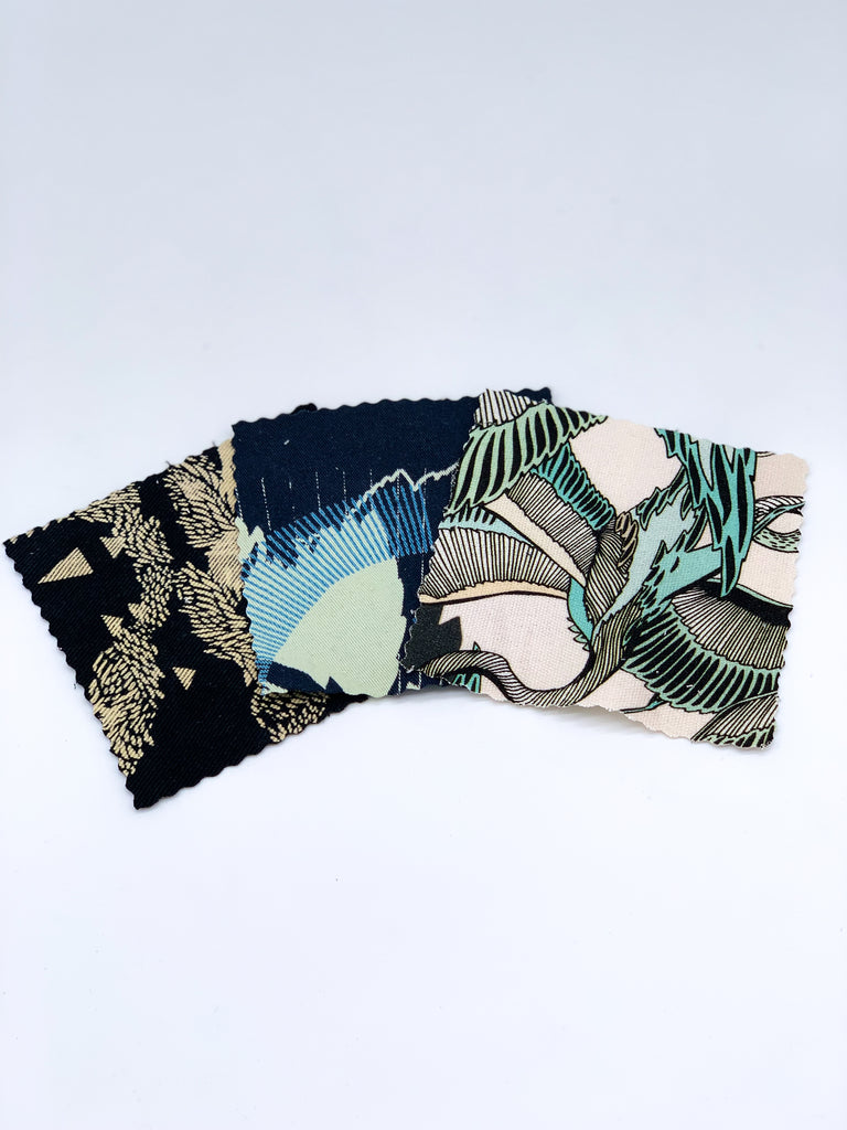 An off- cut fabric box containing dark tone pieces 
