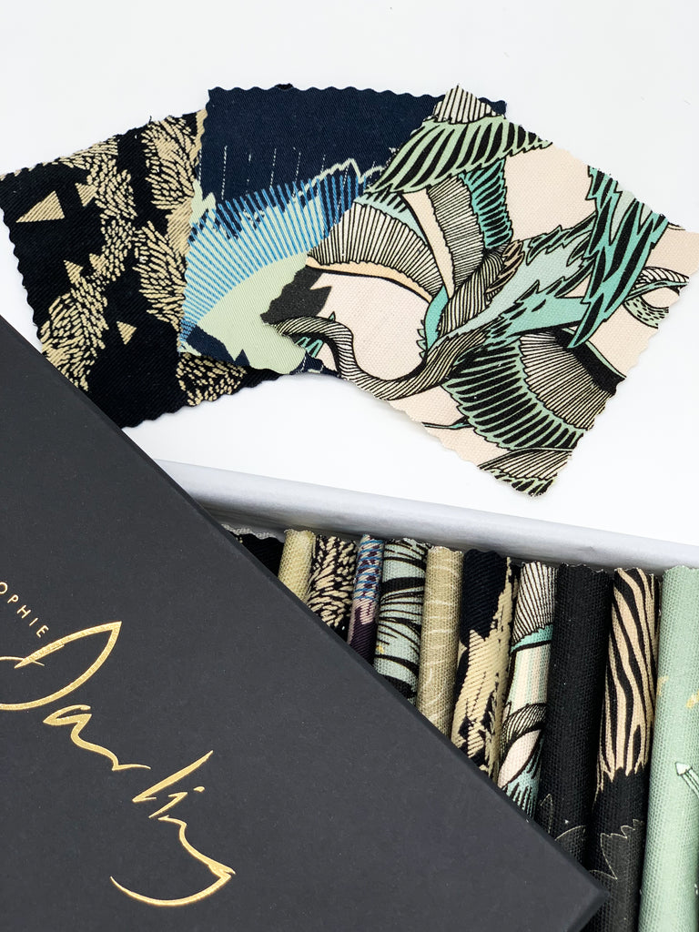 An off- cut fabric box containing dark tone pieces 