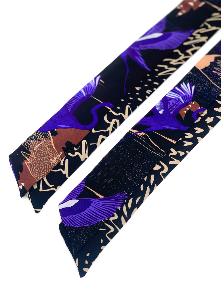A silk printed necktie in black, yellow, pink and purple