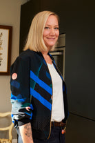 Women wearing a Silk Bomber Jacket with bold blue stripes, geometric lines and pink circles