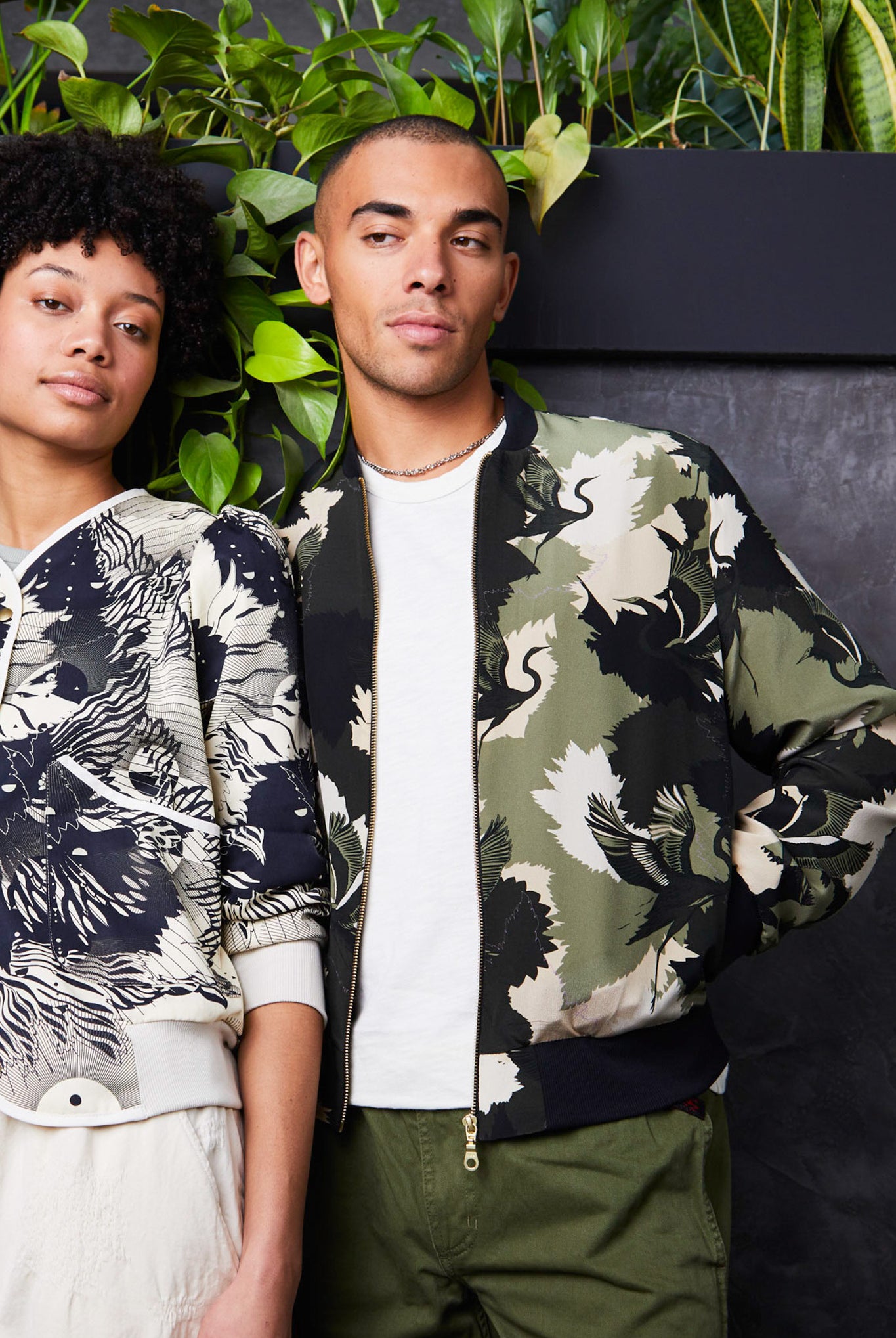 A male wearing a silk mens bomber jacket in a cream and green camouflage print with a stalk design