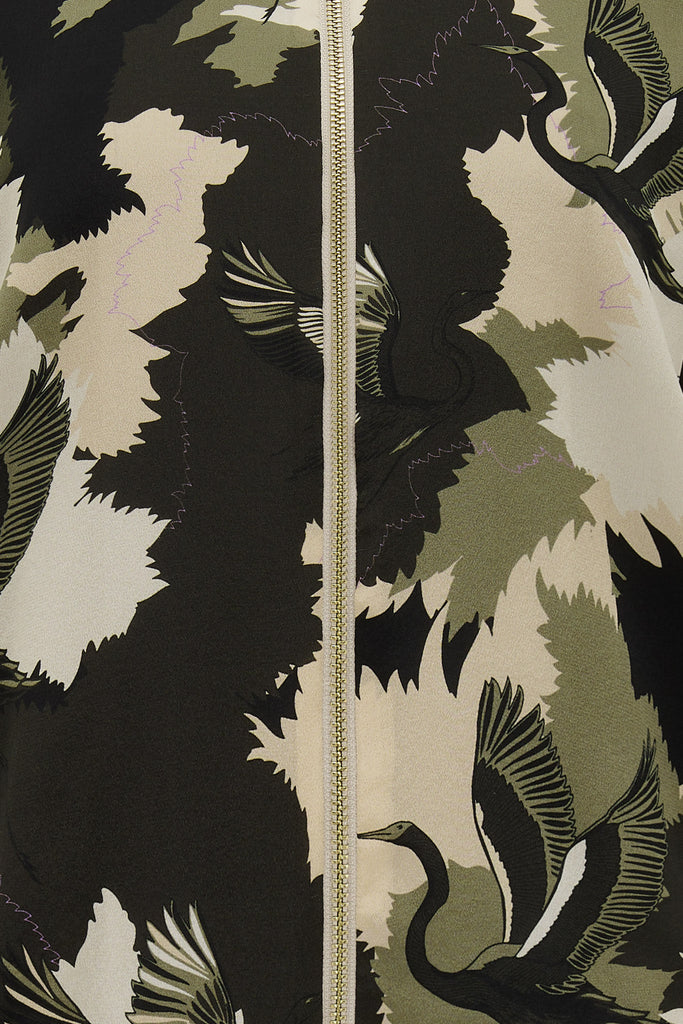 A close up of printed silk bomber jacket in greens and cream camouflage print with stalk details