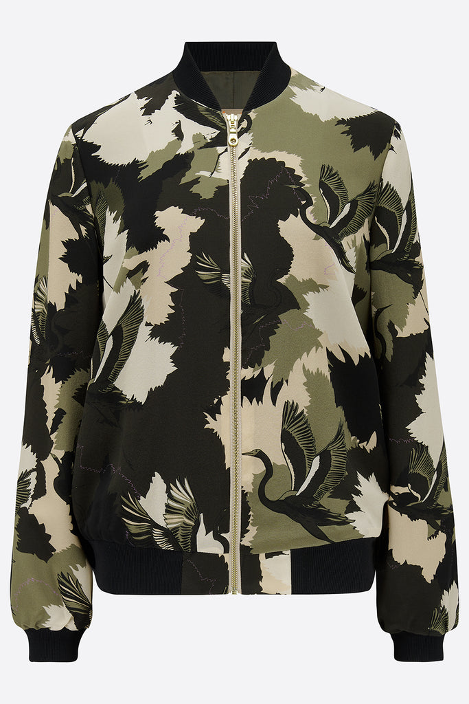 The front of a printed silk bomber jacket in greens and cream camouflage print with stalk details