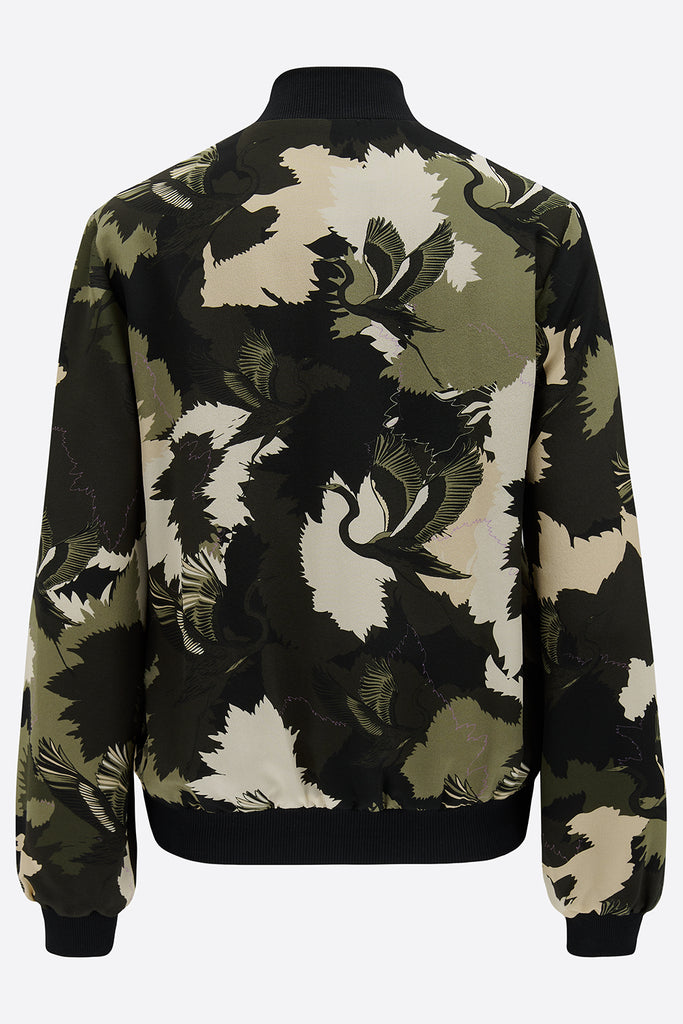 The back of a printed silk bomber jacket in greens and cream camouflage print with stalk details