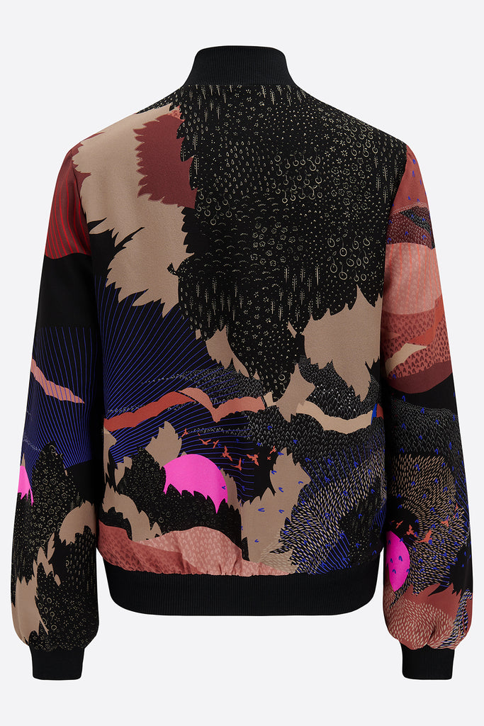 The back of a silk bomber jacket in black and pink with a landscape design and bright pink suns 