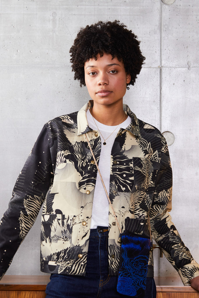A woman wearing a cotton utility jacket in an abstract floral print in navy and cream