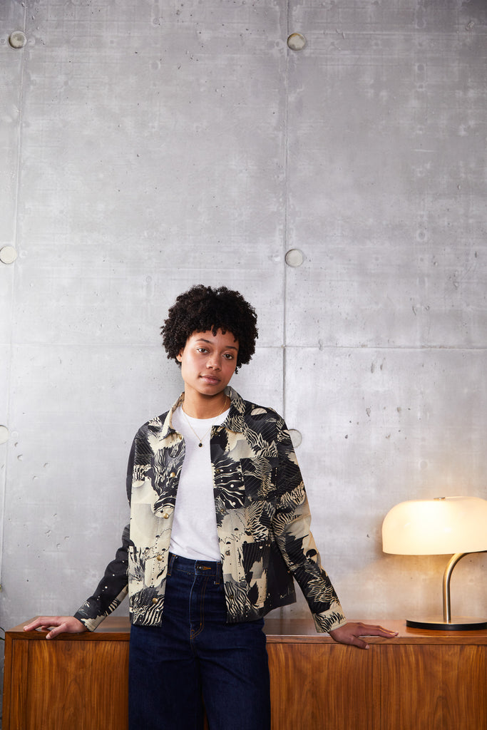 A woman wearing a cotton utility jacket in an abstract floral print in navy and cream
