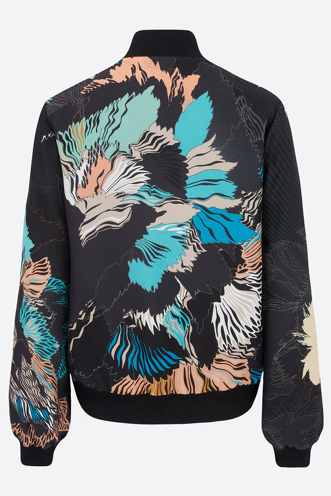 The back of a silk bomber jacket in an abstract floral design in blue, black and coral