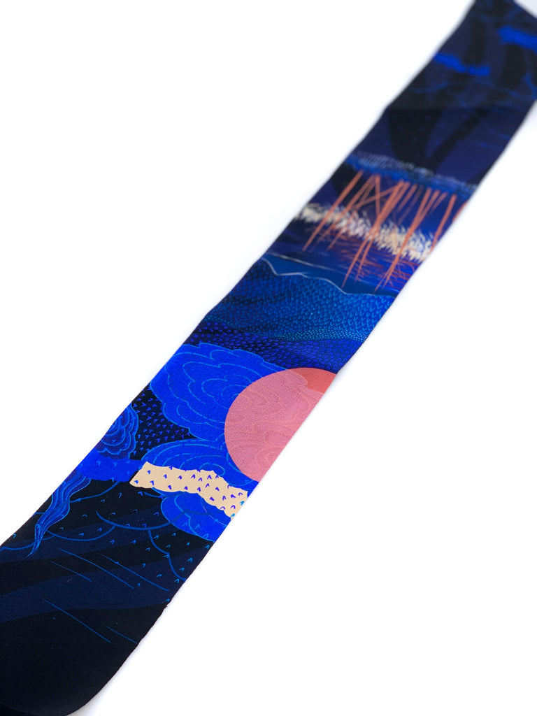A close up of a silk printed headscarf in black and blue
