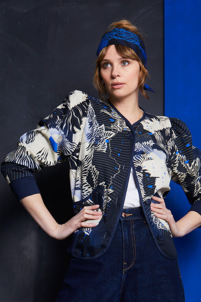 A women wearing a cotton jacket with an abstract floral print in navy and cream