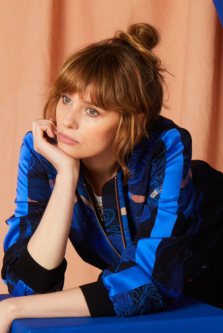 A women wearing a Silk Bomber jacket with Japanese landscapes in blues and pinks