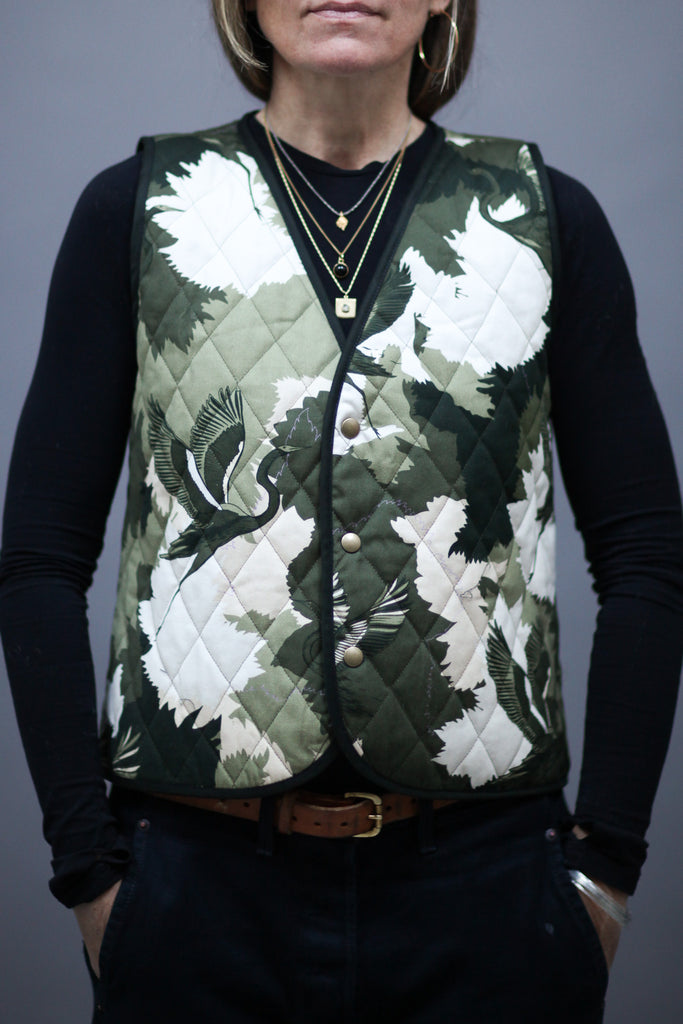 A woman wearing a cotton printed waistcoat in black, white and green