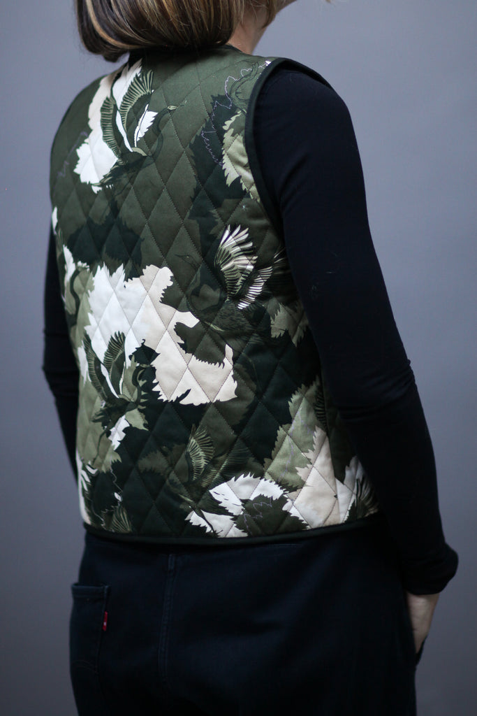 A woman wearing a cotton printed waistcoat in black, white and green