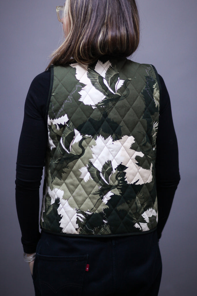 A woman wearing a cotton printed waistcoat in black, white and green