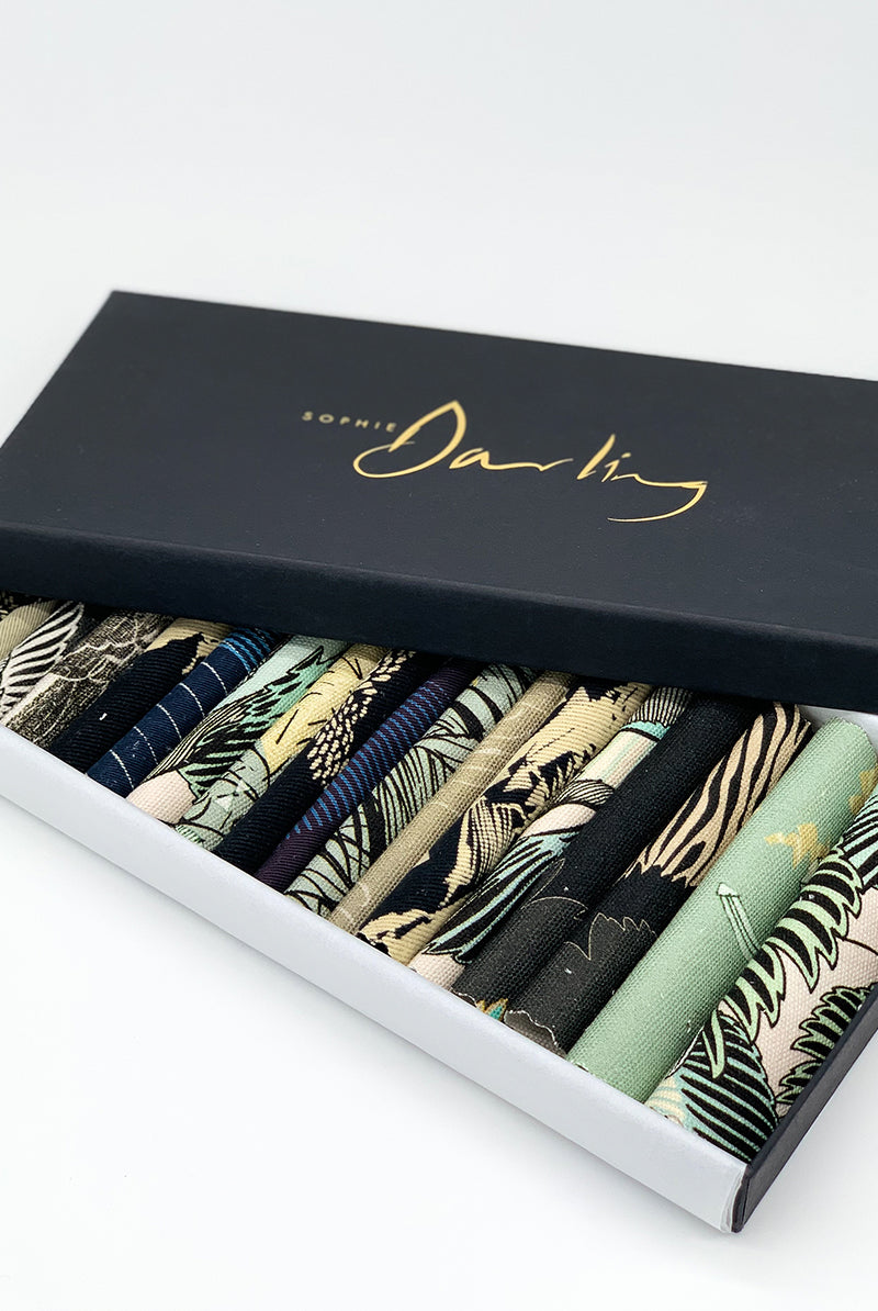 An off- cut fabric box containing dark tone pieces 