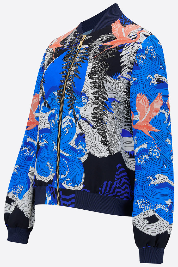 Side view of silk bomber jacket in blue, white and coral with waves and birds design