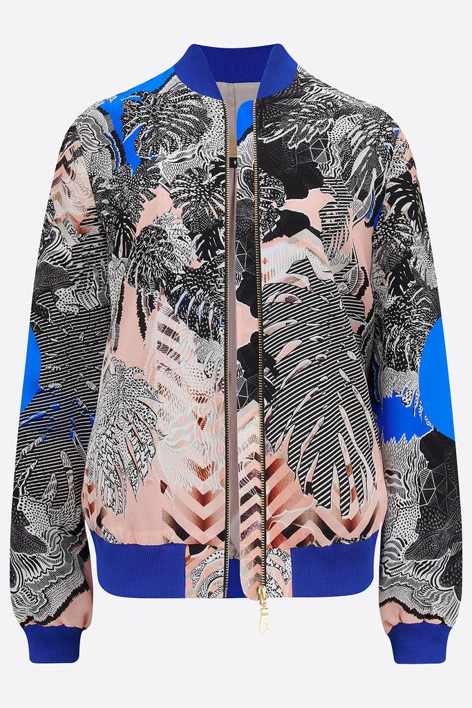 The front of an unzipped silk bomber jacket in blue, pink and monochrome tropical print