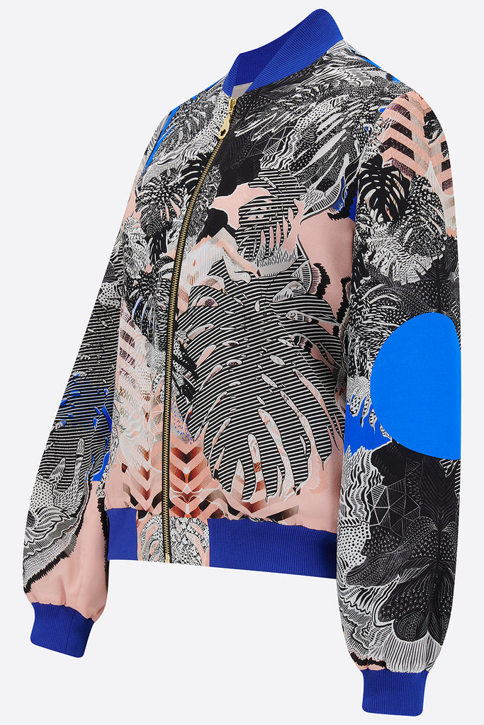 The side of a silk bomber jacket in blue, pink and monochrome tropical print