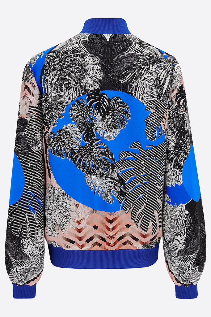 The back of a silk bomber jacket in blue, pink and monochrome tropical print