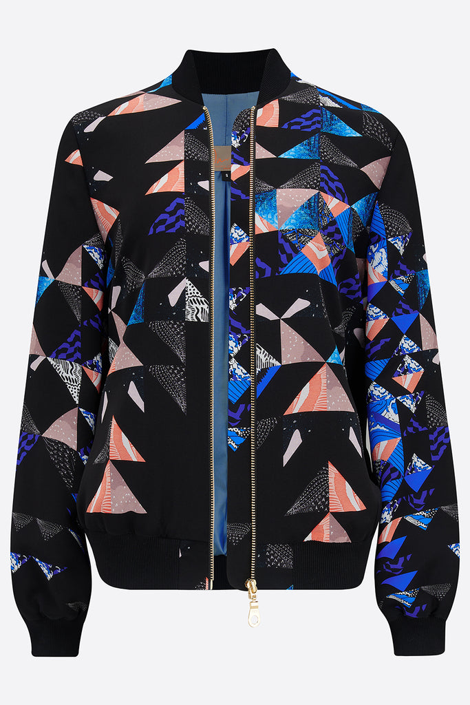 An unzipped silk bomber jacket with a collaged geometric print in black, blue and pink