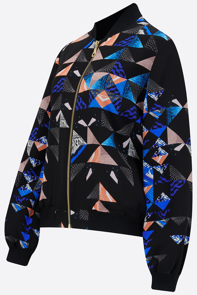 The side of a silk bomber jacket with a collaged geometric print in black, blue and pink
