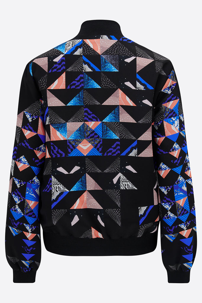 The back of a silk bomber jacket with a collaged geometric print in black, blue and pink